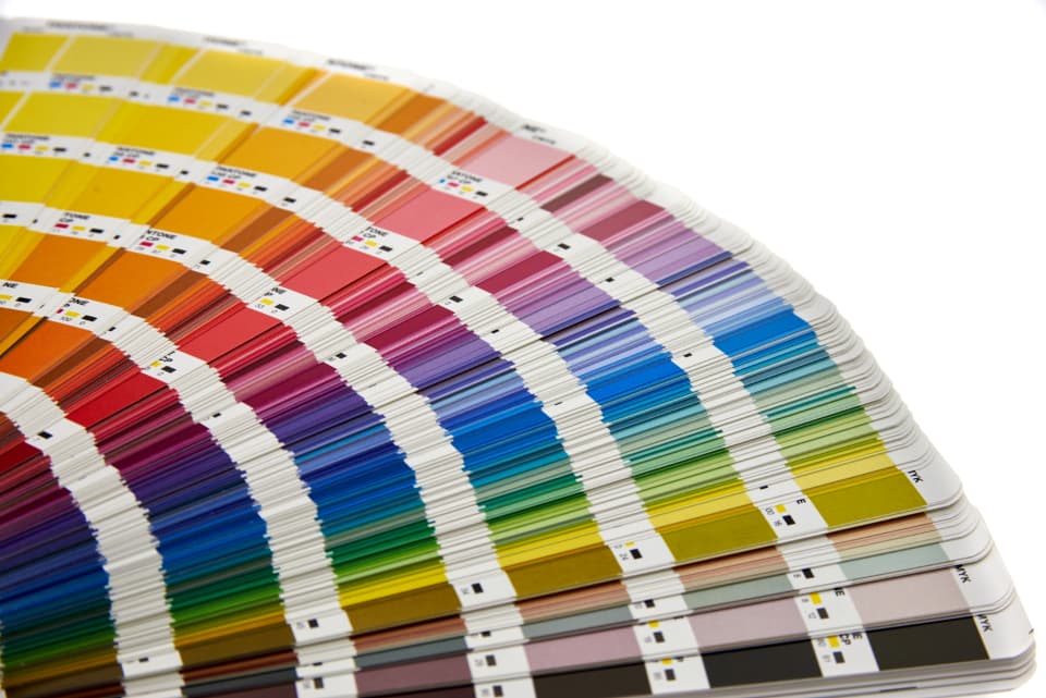 Paint colour swatches and sample boards against a wall in natural light