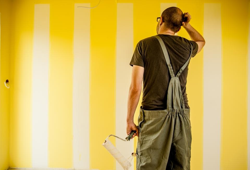 Painting crew working in a partially finished room with protected floors